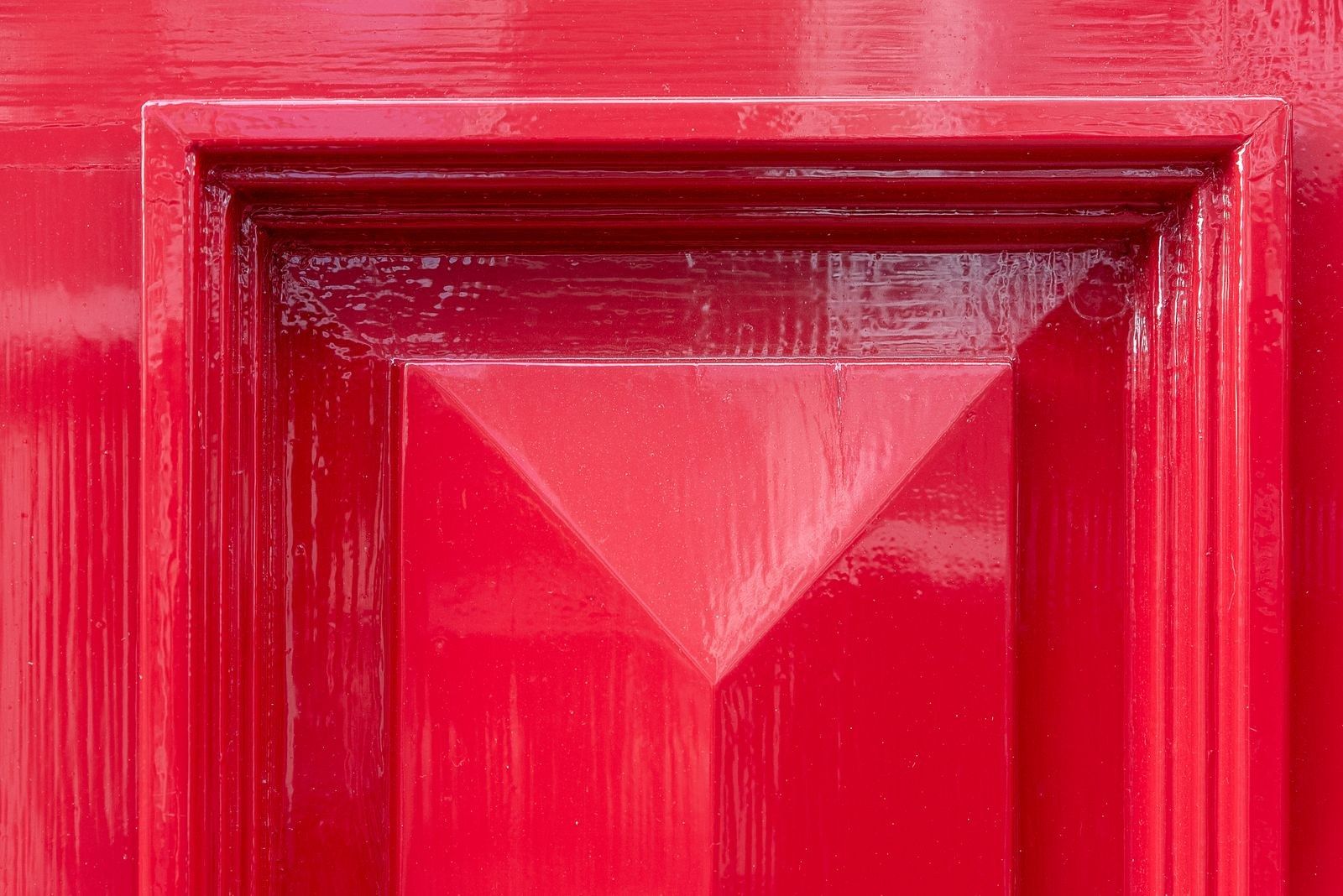 Rot lackierte Kassettentür mit glänzender Oberfläche, aus der Nähe