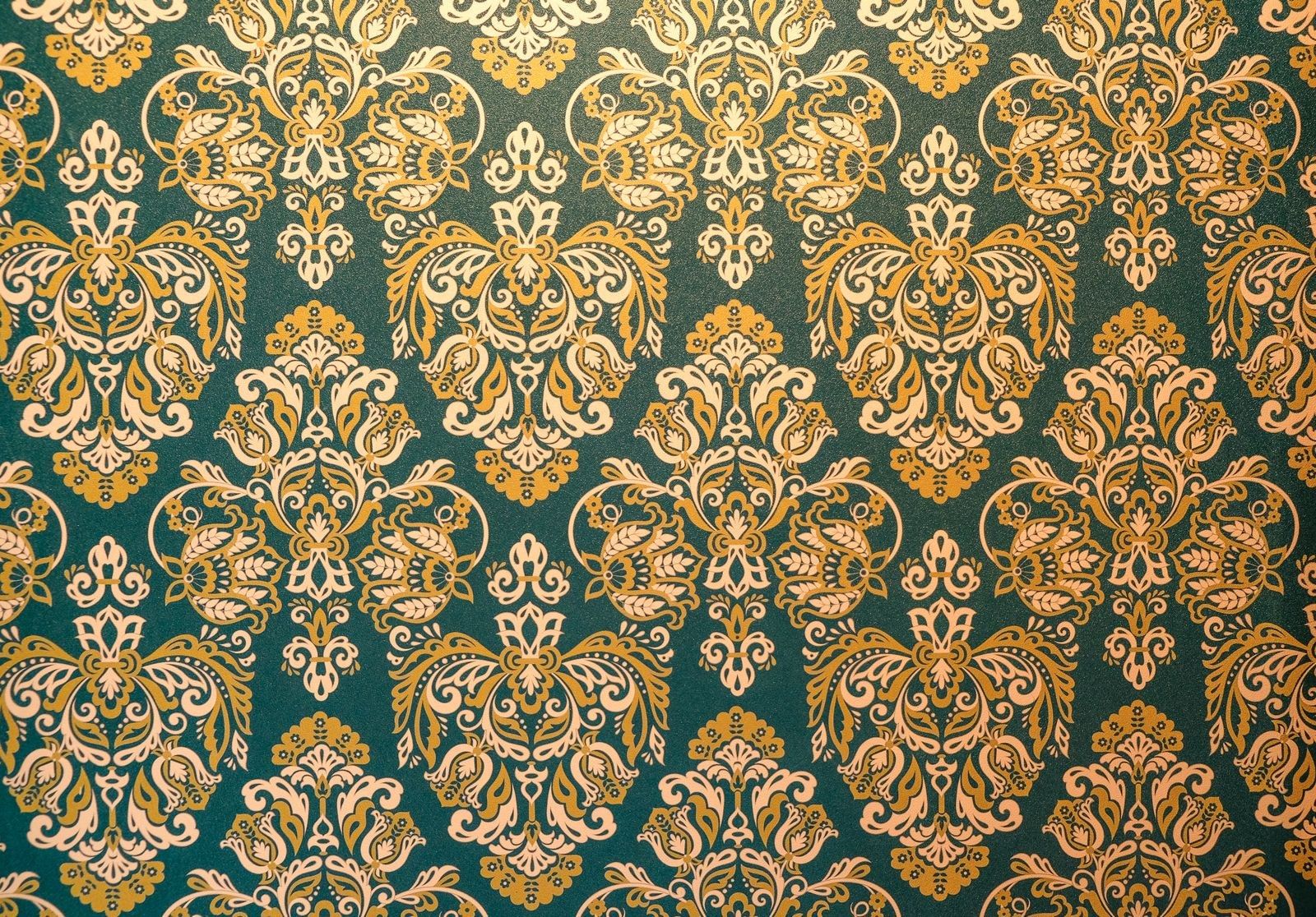 Tapete mit goldenem Ornament auf dunkelgrünem Grund, aus der Nähe